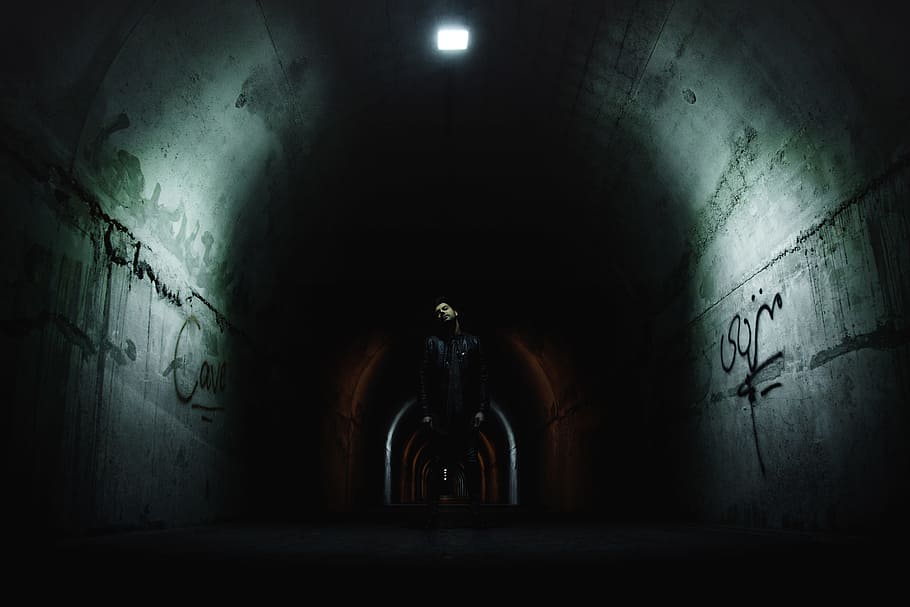 man standing in the middle of the tunnel under the light, wall HD wallpaper