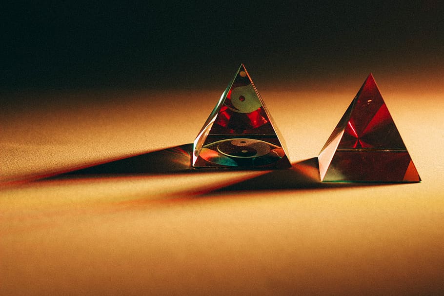 two red pyramid decors on brown top, still life, paper, indoors HD wallpaper